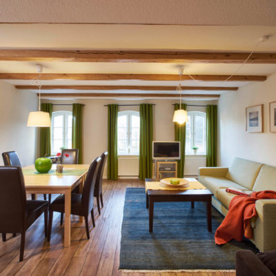 Wohnzimmer mit Esstisch Sofa und Fernseher Ferienwohnung